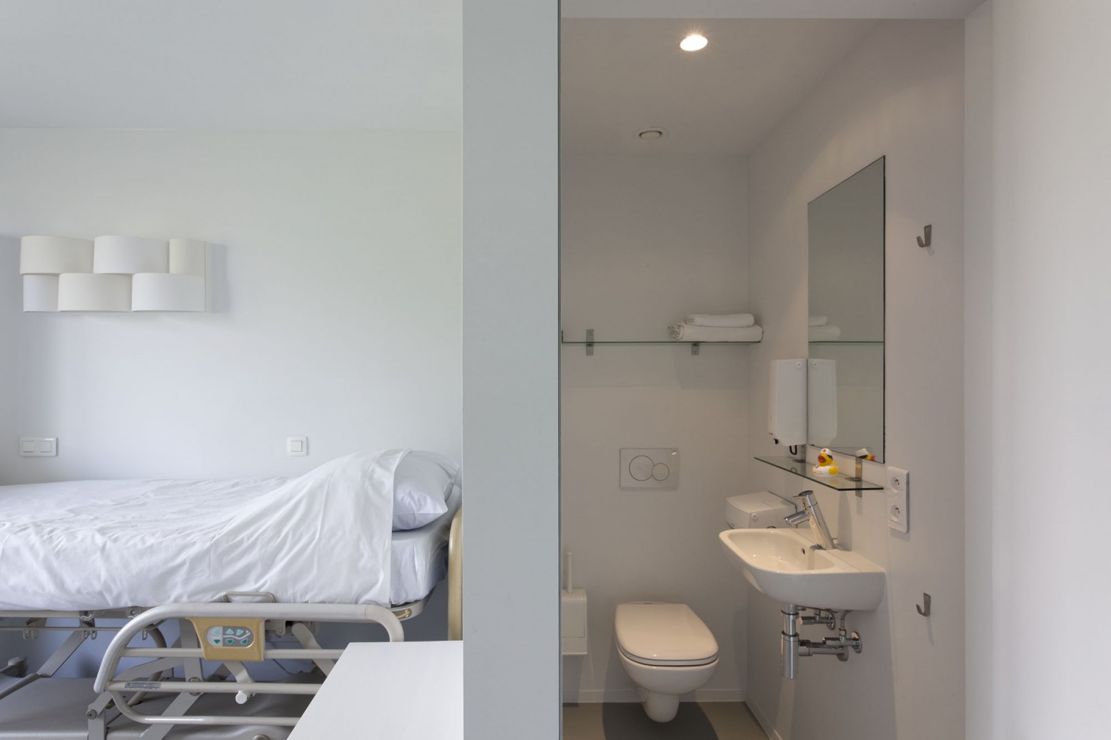 A single room in the guesthouse at o2 Clinic, including a bed and private bathroom.